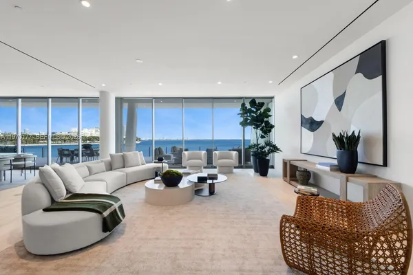 a living room with furniture kitchen view and large windows