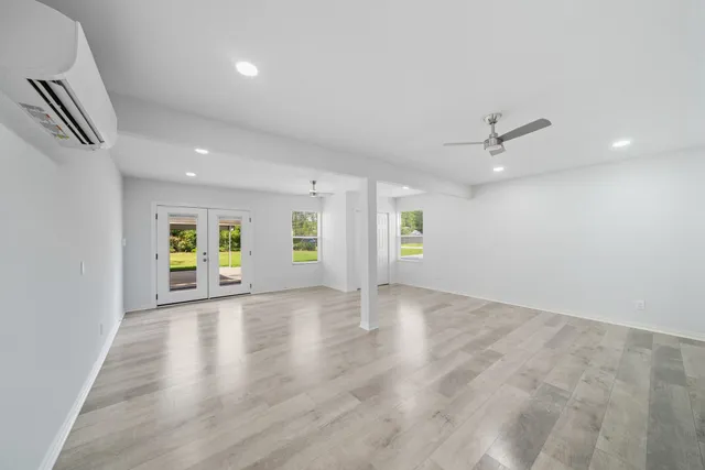 an empty room with windows and wooden floor