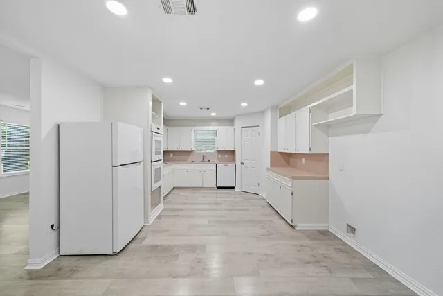 a view of a kitchen with white cabinets