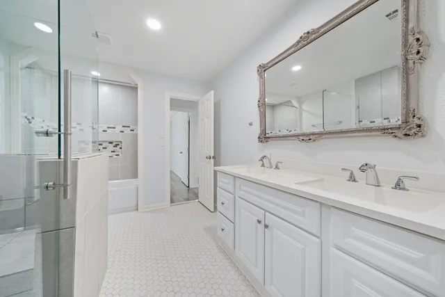a bathroom with a double vanity sink mirror and shower
