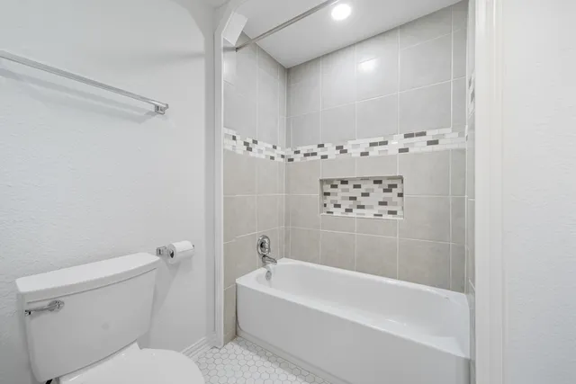 a bathroom with a bathtub a toilet and a shower