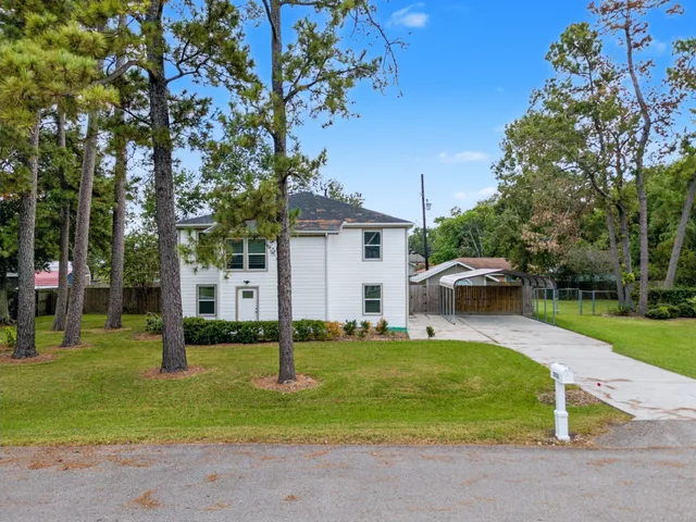 a view of a house with backyard and a tree
