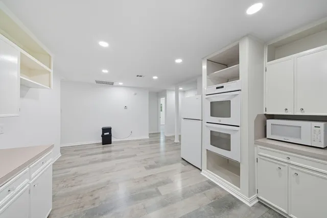 a view of a kitchen with white cabinets