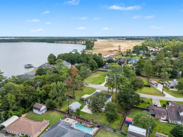 an aerial view of a house with a yard and lake view