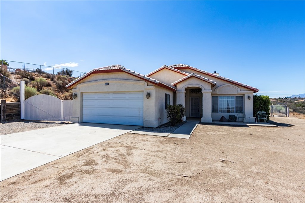 7170 Joshua Road Oak Hills, CA 92344 - Photo 15 of 58 a front view of a house with a yard and garage