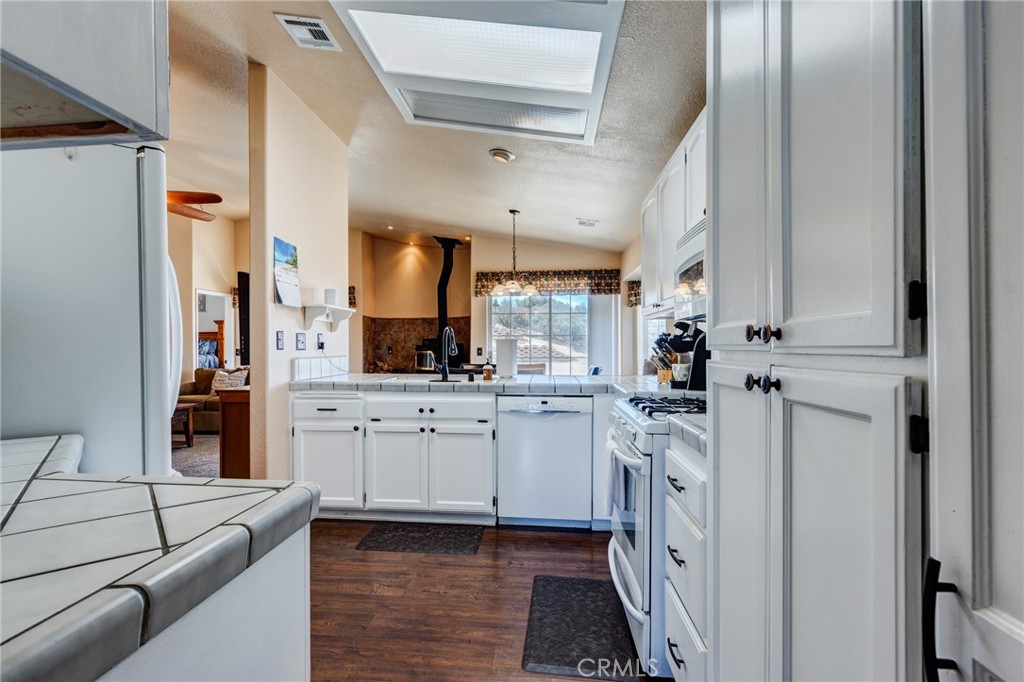 7170 Joshua Road Oak Hills, CA 92344 - Photo 22 of 58 a kitchen with white cabinets and white appliances