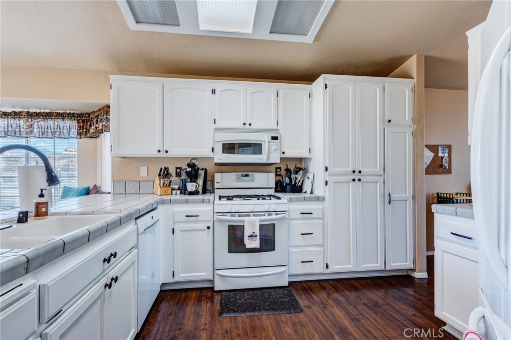 7170 Joshua Road Oak Hills, CA 92344 - Photo 24 of 58 a kitchen with cabinets stainless steel appliances and wooden floor