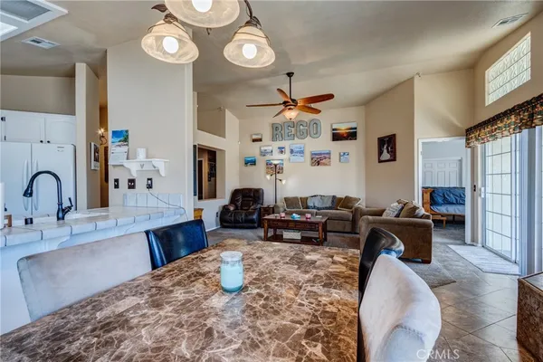 a living room with furniture a dining table and a flat screen tv
