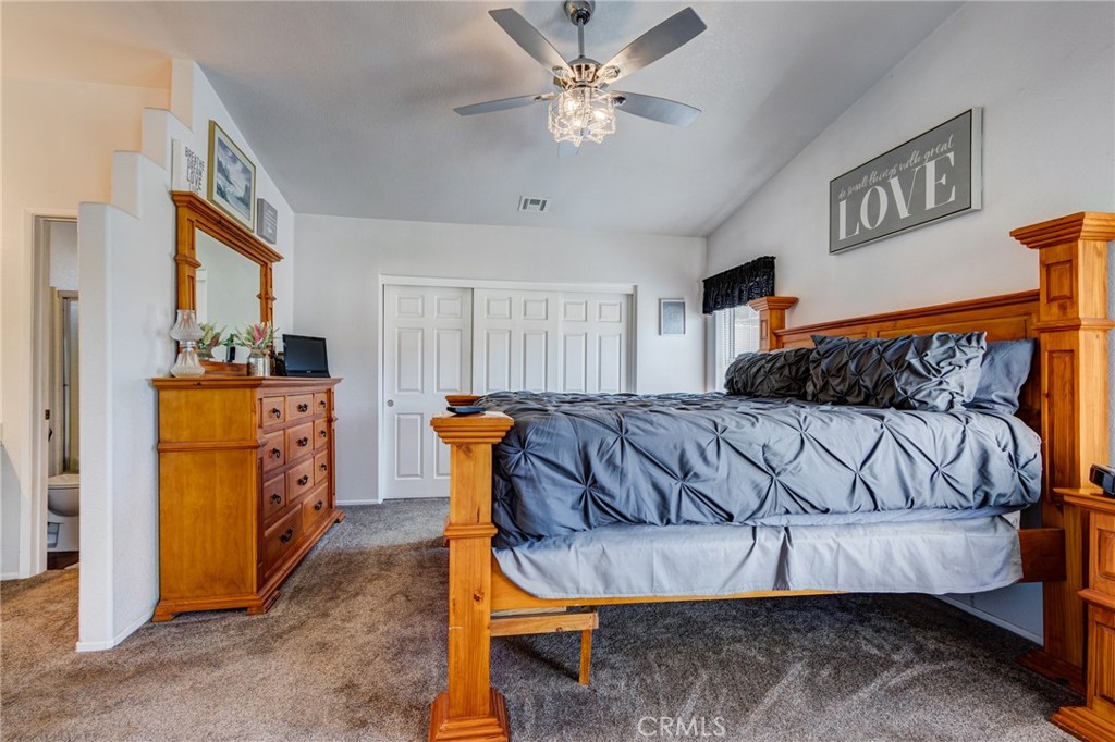 7170 Joshua Road Oak Hills, CA 92344 - Photo 41 of 58 a bedroom with a bed and a chandelier