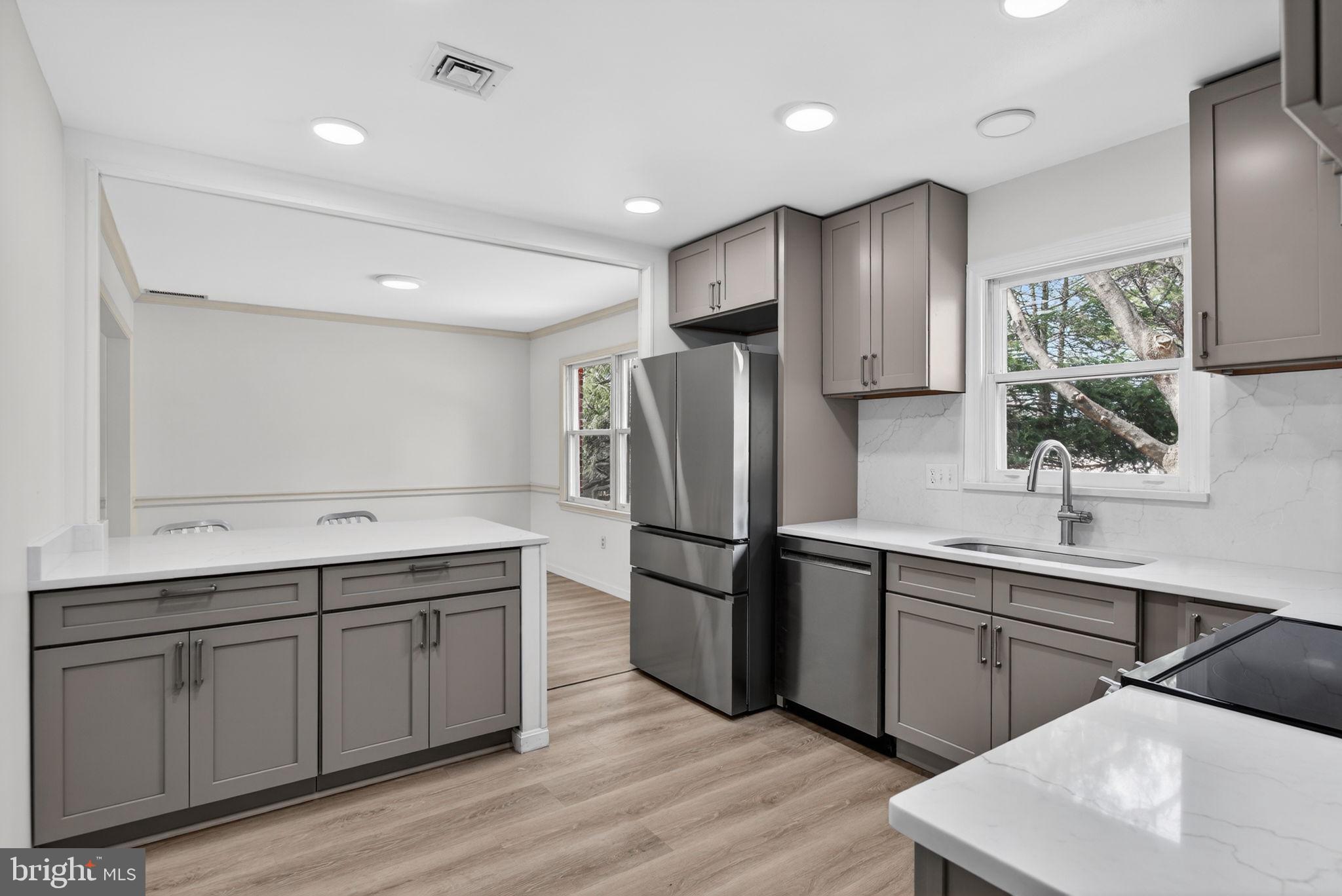 2348 Henbird Lane Lancaster, PA 17601 - Photo 15 of 58 a kitchen with stainless steel appliances granite countertop a sink a stove a refrigerator and island with wooden floor