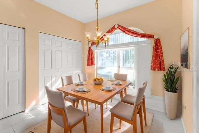 24088 Buckingham Way Punta Gorda, FL 33980 - Photo 8 of 37 a dining room with furniture potted plants and wooden floor