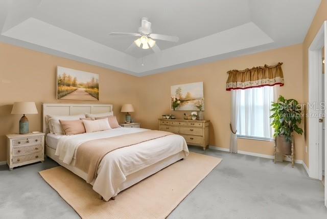 24088 Buckingham Way Punta Gorda, FL 33980 - Photo 9 of 37 a bedroom with a bed and a chandelier