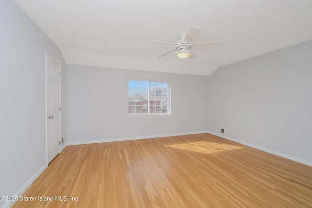 a view of a room with wooden floor and a ceiling fan