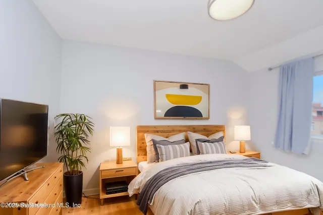 a bedroom with a bed and a flat screen tv