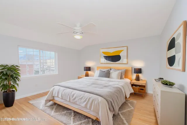 a bedroom with a bed and a potted plant