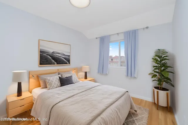 a bedroom with a bed and a potted plant