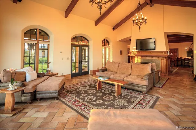 a view of a dining room and livingroom with furniture wooden floor a chandelier