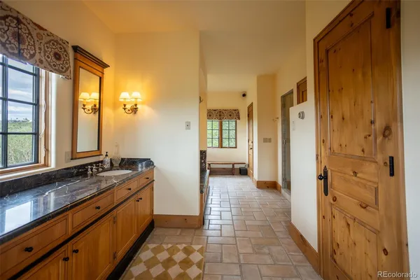 a bathroom with a granite countertop sink and tub