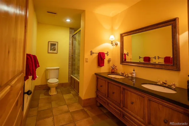 a spacious bedroom with a bed and a chandelier