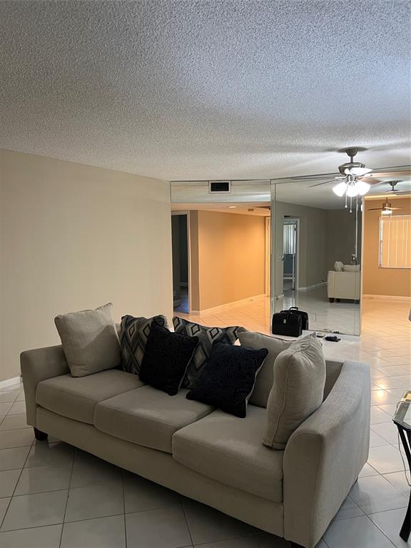 1605 Abaco Drive, Unit 1605 J1 Coconut Creek, FL 33066 - Photo 22 of 71 a living room with furniture and a large mirror
