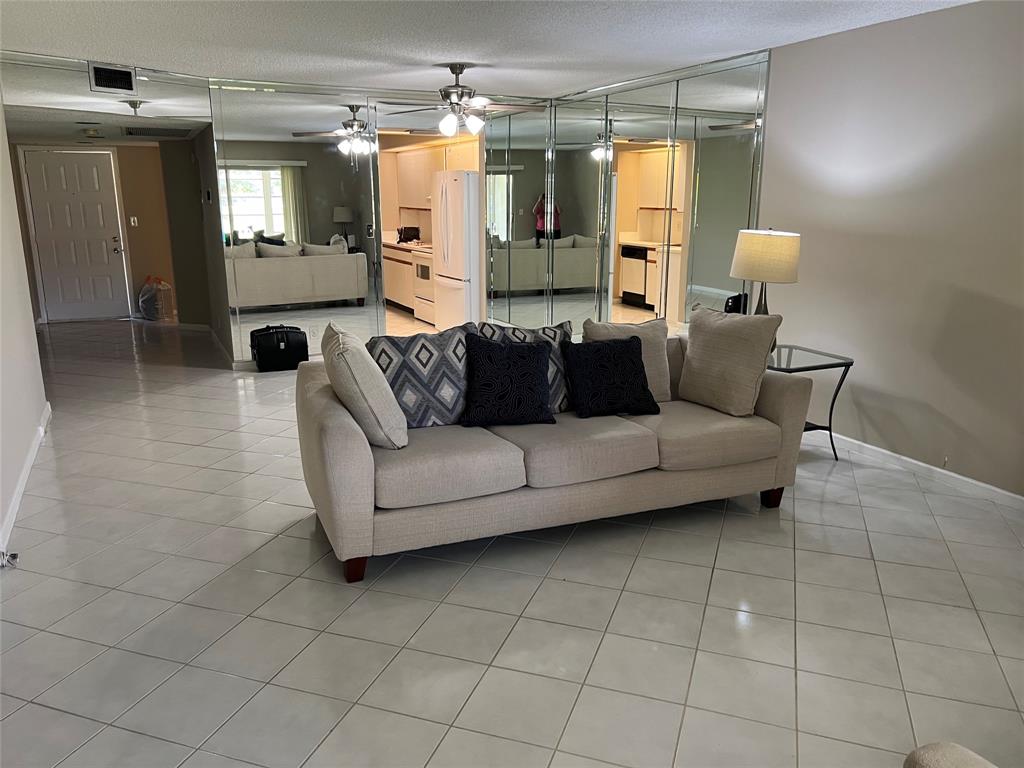 1605 Abaco Drive, Unit 1605 J1 Coconut Creek, FL 33066 - Photo 36 of 71 a living room with furniture and a chandelier