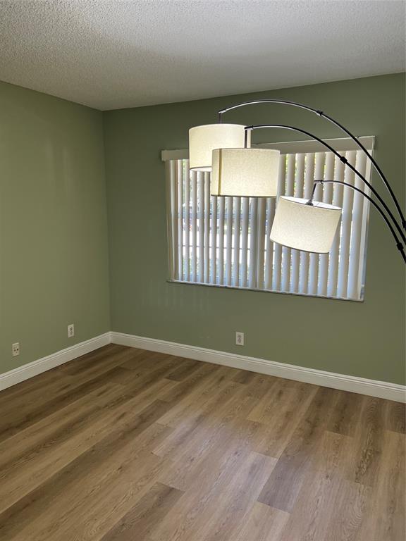 1605 Abaco Drive, Unit 1605 J1 Coconut Creek, FL 33066 - Photo 38 of 71 an empty room with wooden floor and windows