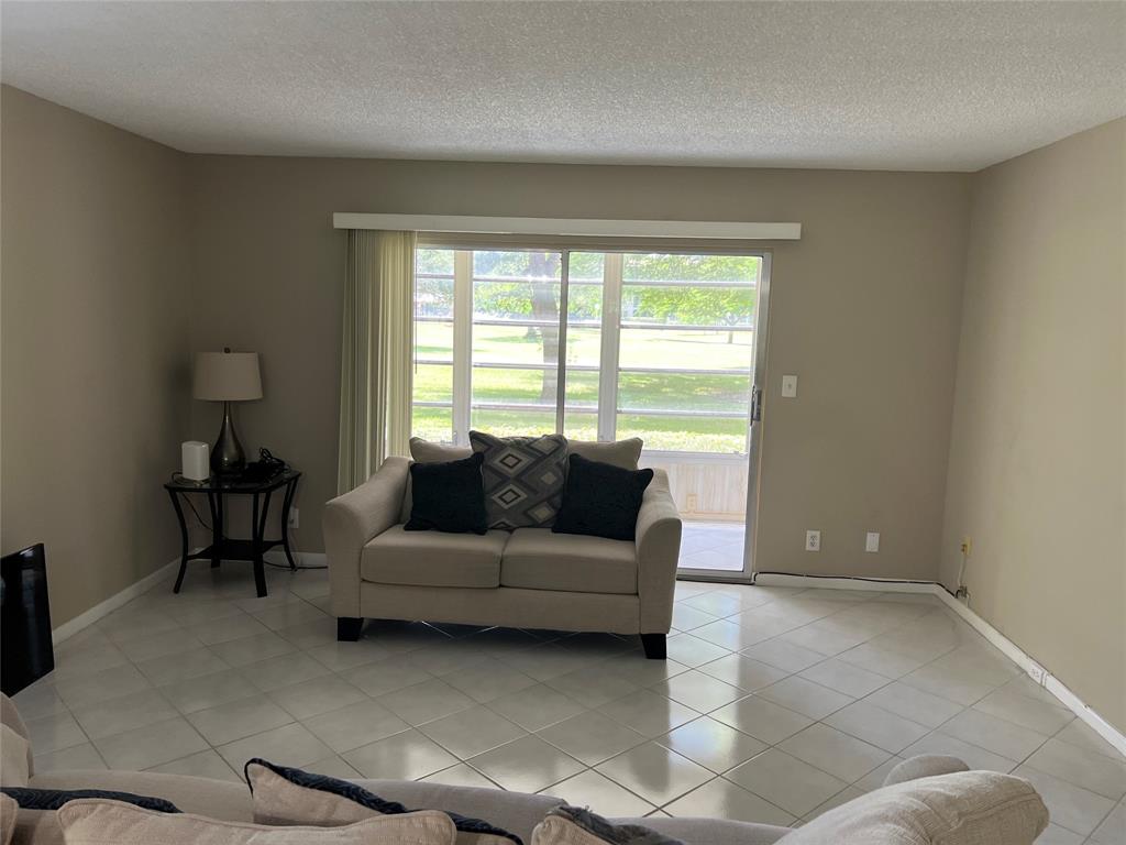 1605 Abaco Drive, Unit 1605 J1 Coconut Creek, FL 33066 - Photo 4 of 71 a living room with furniture and a window
