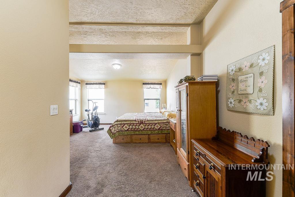 414 South Garfield Street Genesee, ID 83832 - Photo 21 of 50 Carpeted bedroom featuring a textured ceiling and a textured wall