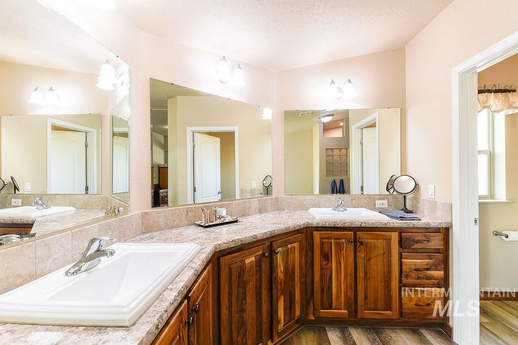 414 South Garfield Street Genesee, ID 83832 - Photo 27 of 50 Full bathroom featuring double vanity, dark wood-style floors, and a textured ceiling