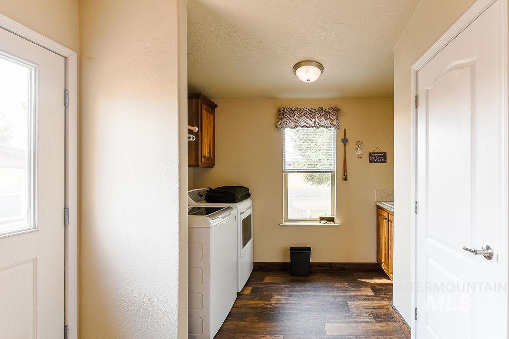 414 South Garfield Street Genesee, ID 83832 - Photo 33 of 50 Laundry area featuring cabinet space, dark wood-type flooring, washer and clothes dryer, and a textured ceiling