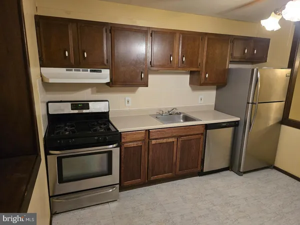 a kitchen with a sink stove and refrigerator
