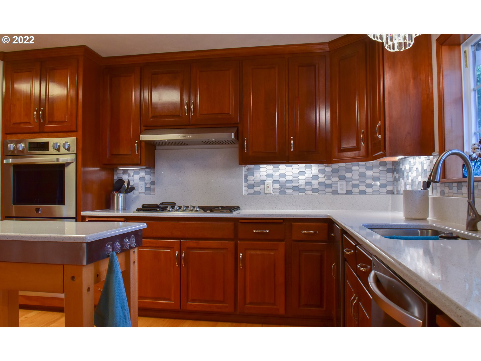 6874 Forsythia Street Springfield, OR 97478 - Photo 10 of 28 a kitchen with granite countertop wooden cabinets a sink a stove and a oven
