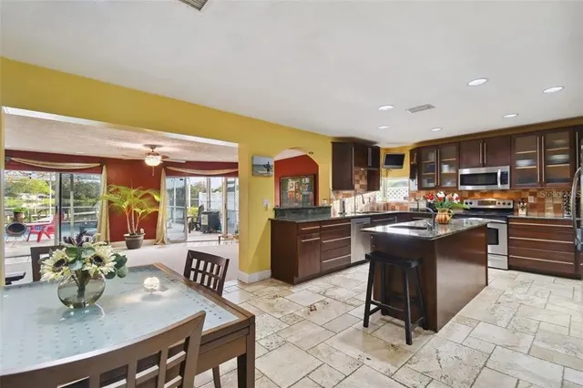 a kitchen with granite countertop a sink counter top space and stainless steel appliances