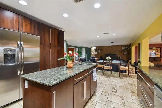 a kitchen with granite countertop kitchen island stainless steel appliances a sink and counter space