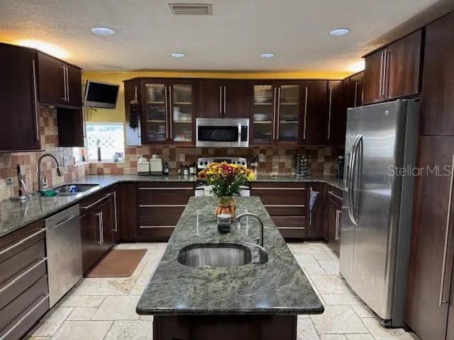 a kitchen with a refrigerator sink and cabinets