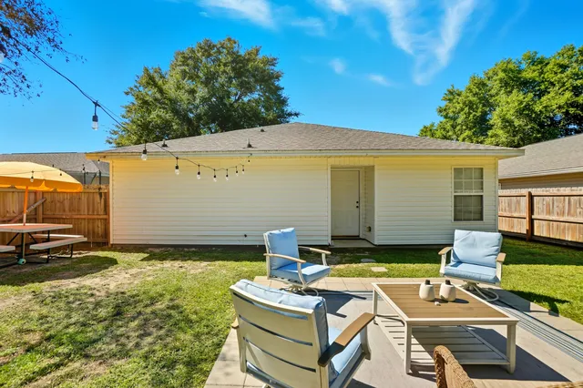 a view of a patio with table and chairs and potted plants