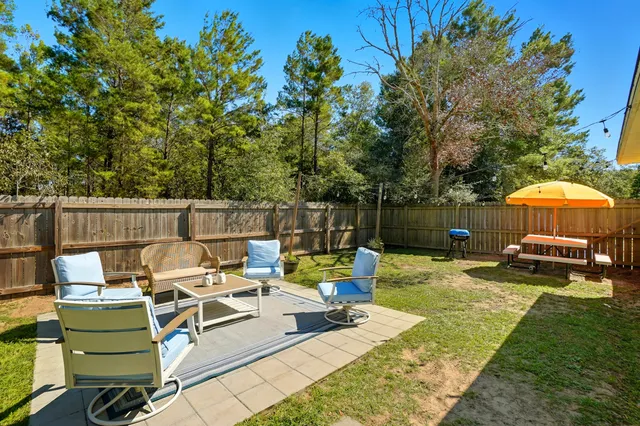 a backyard of a house with table and chairs