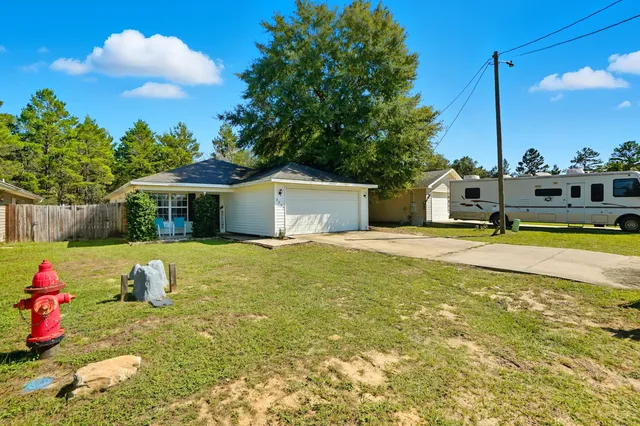 a view of a house with a backyard and a tree