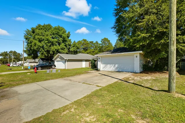 a front view of a house with a yard and trees