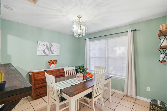 a dining room with furniture a chandelier and window