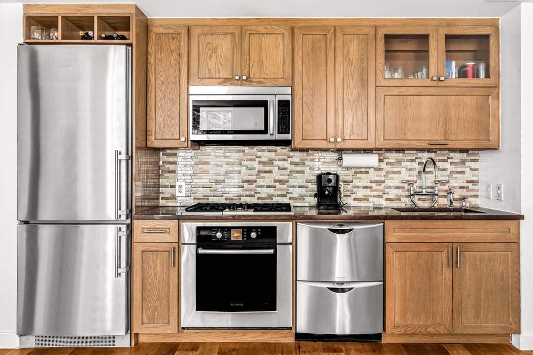 a kitchen with stainless steel appliances granite countertop a refrigerator stove top oven and sink