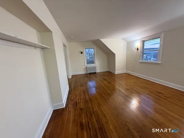 a view of empty room with wooden floor