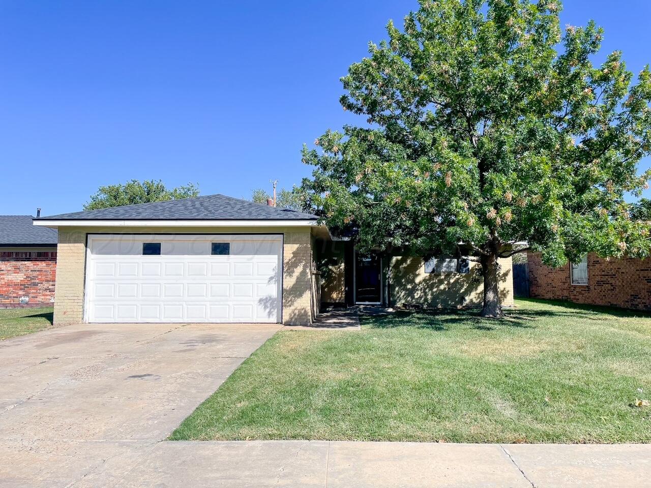 a view of a yard in front of a house with garage