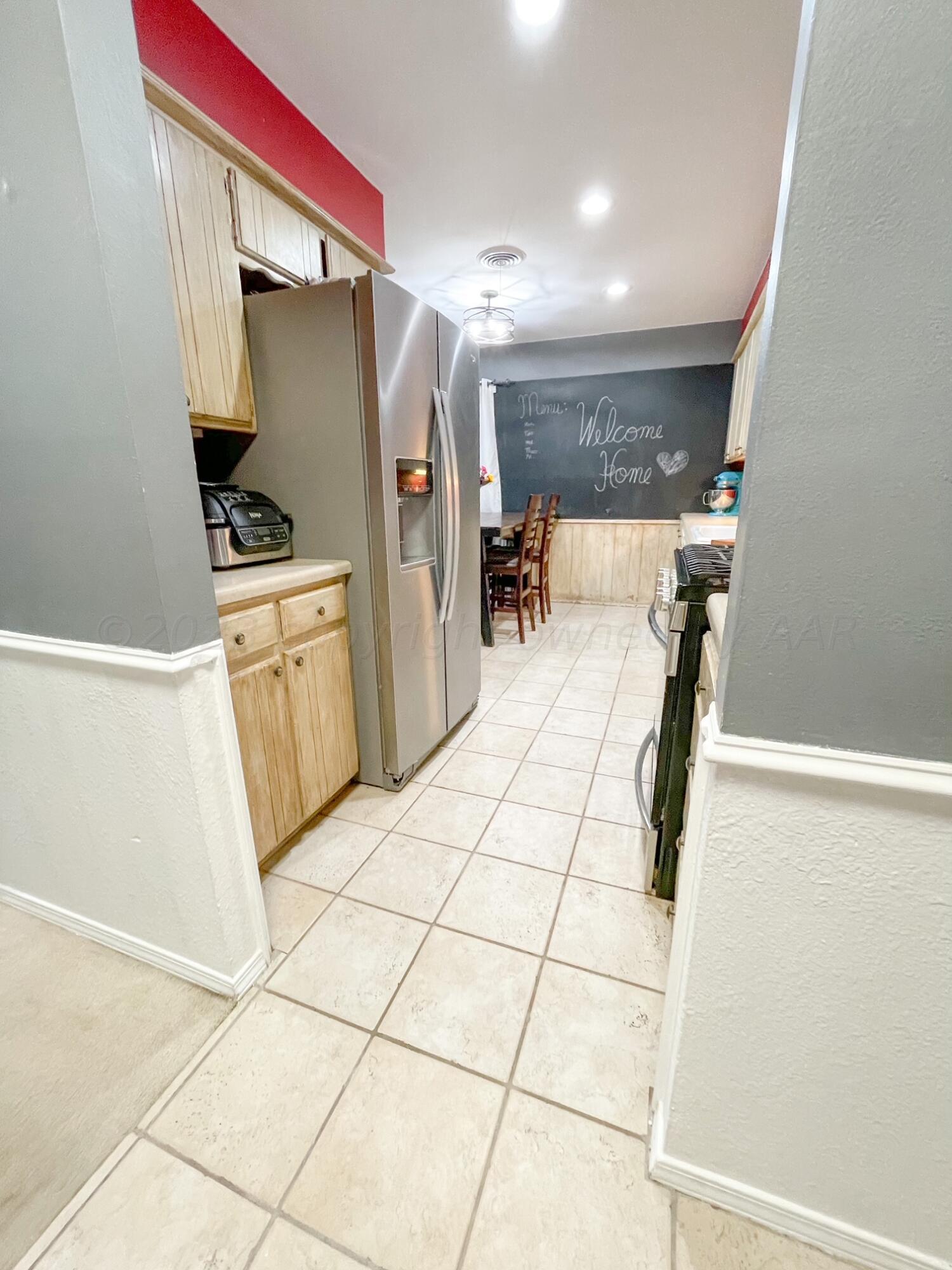 5317 Capulin Lane Amarillo, TX 79110 - Photo 15 of 19 a bedroom with a bed and a refrigerator
