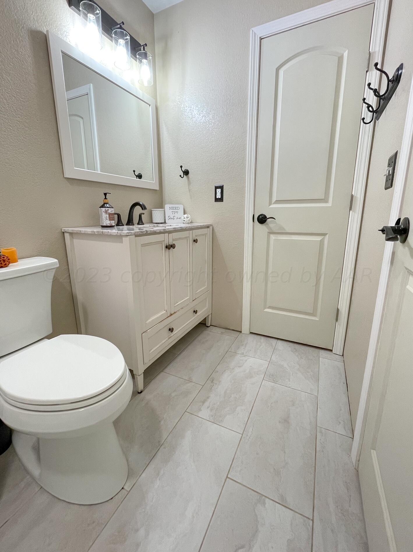 5317 Capulin Lane Amarillo, TX 79110 - Photo 16 of 19 a bathroom with a sink a toilet and mirror