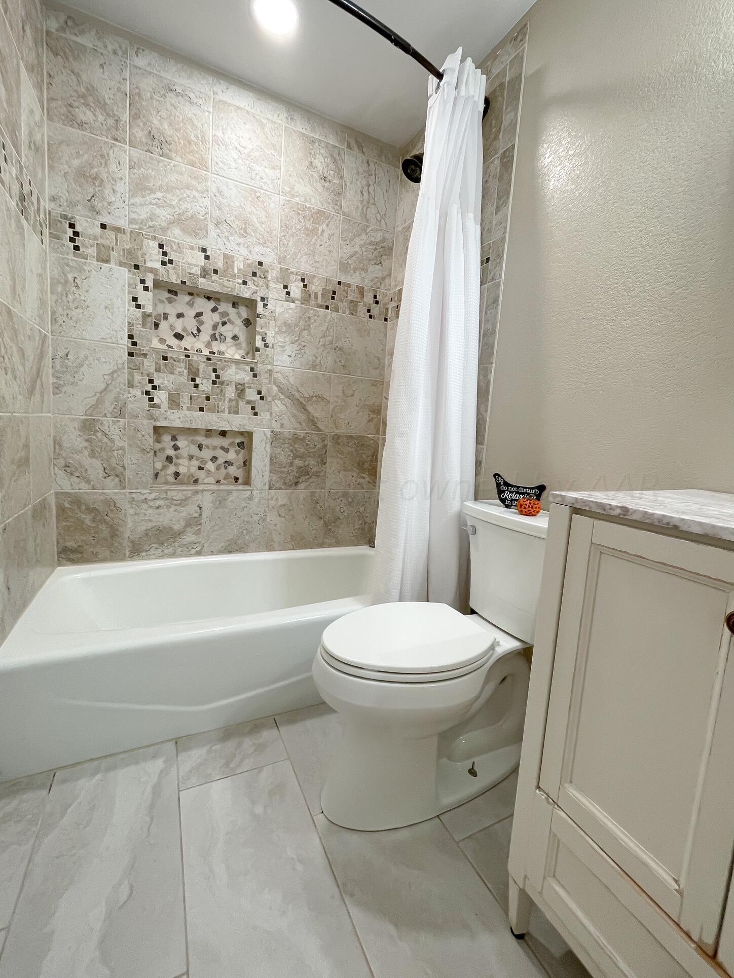 5317 Capulin Lane Amarillo, TX 79110 - Photo 17 of 19 a bathroom with a toilet and a shower