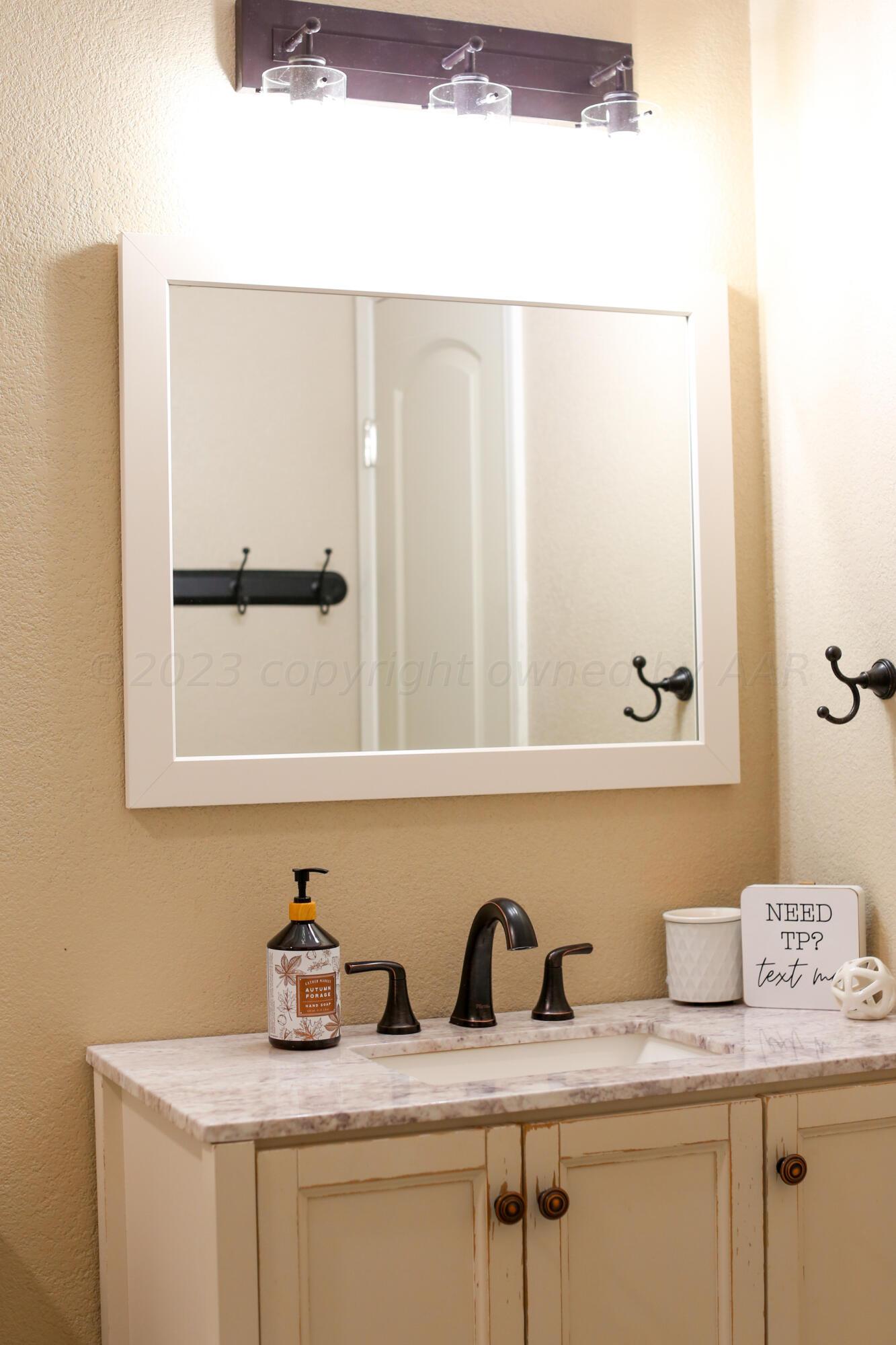 5317 Capulin Lane Amarillo, TX 79110 - Photo 18 of 19 a bathroom with a sink and a mirror