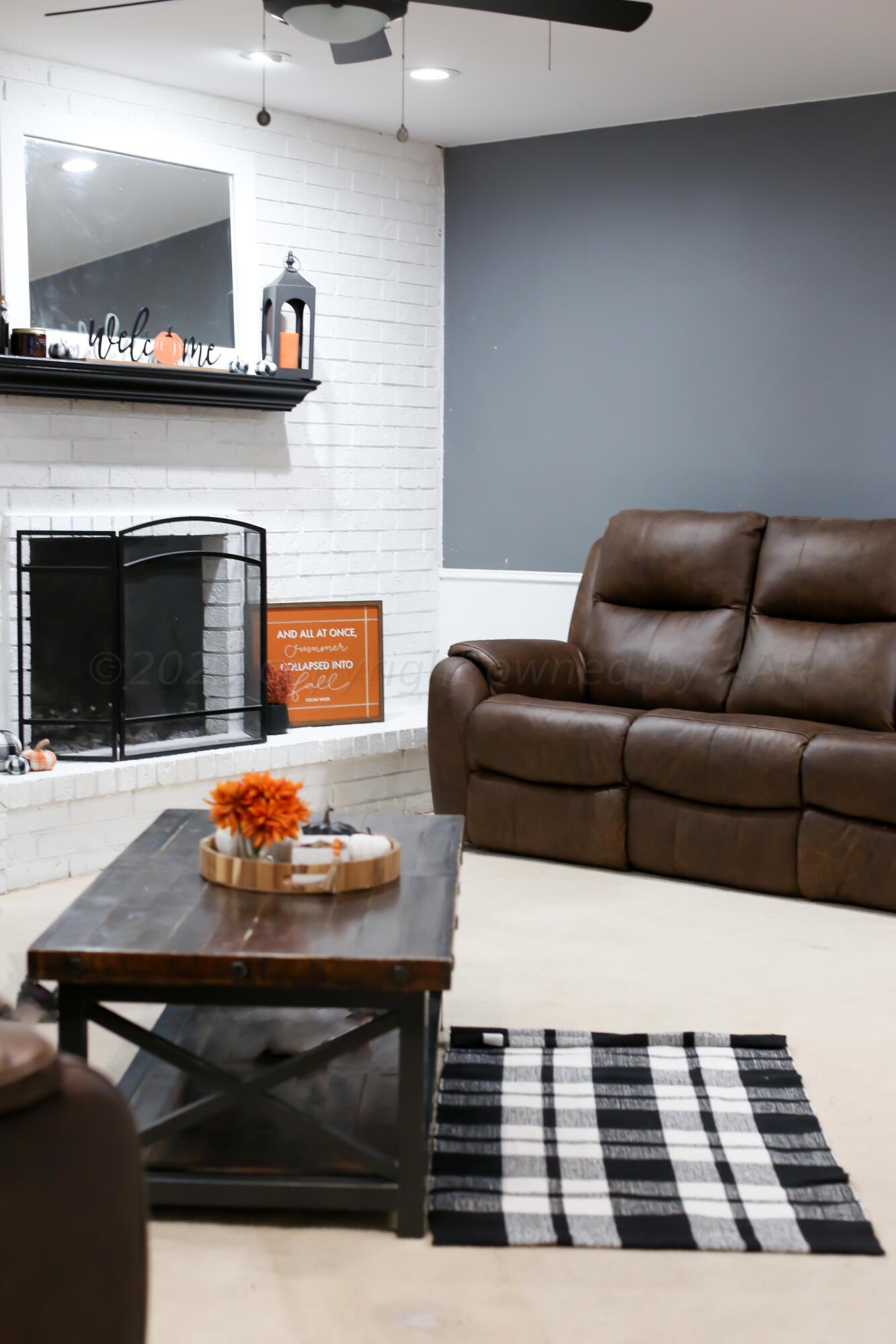 5317 Capulin Lane Amarillo, TX 79110 - Photo 2 of 19 a living room with furniture a flat screen tv and a fireplace