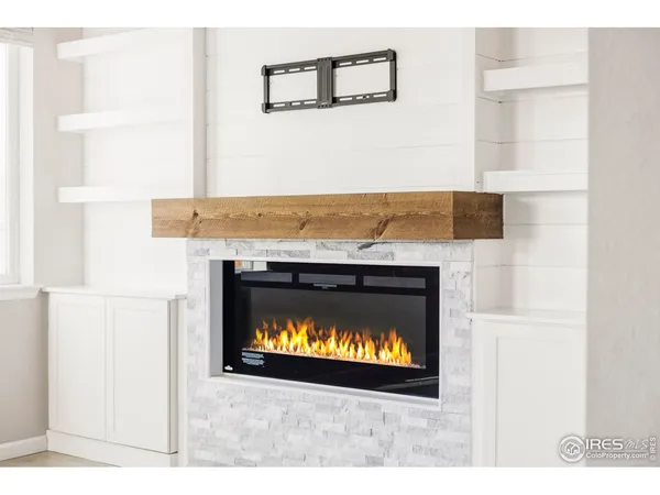 a view of an empty room with a window and fireplace