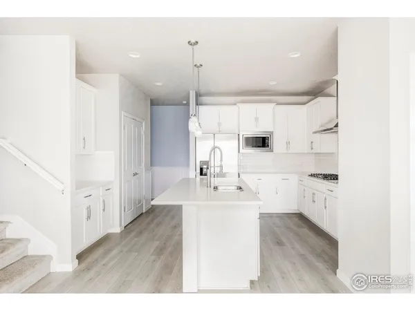 a living room with stainless steel appliances furniture and a fireplace